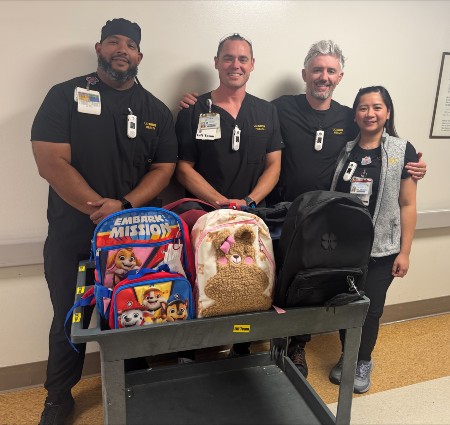 Lift team holding donated backpacks 